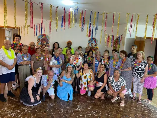 Turma fantasiada para o carnaval, sob o teto coberto de serpentina colorida