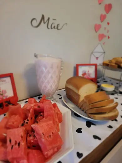 Mesa do café do Dia das Mães, com melancia cortada, pão caseiro e bolo